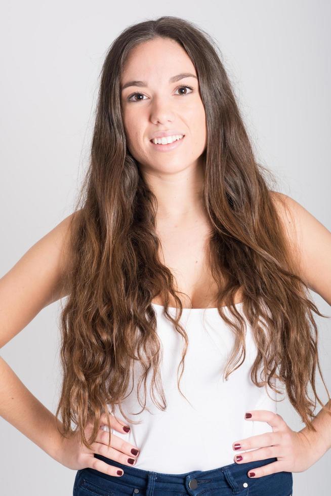 mulher com cabelo comprido vestindo camiseta branca e calça jeans foto