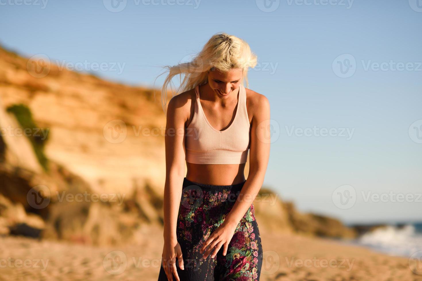 mulher curtindo o pôr do sol em uma bela praia foto