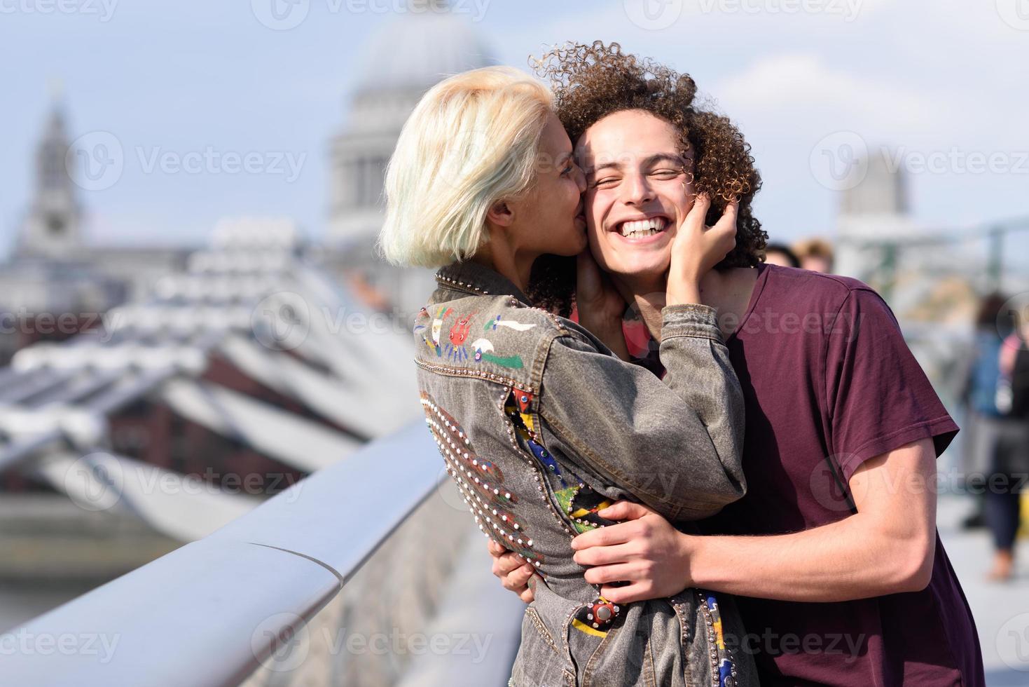 casal feliz abraçando a ponte do milênio, rio Tamisa, em Londres. foto