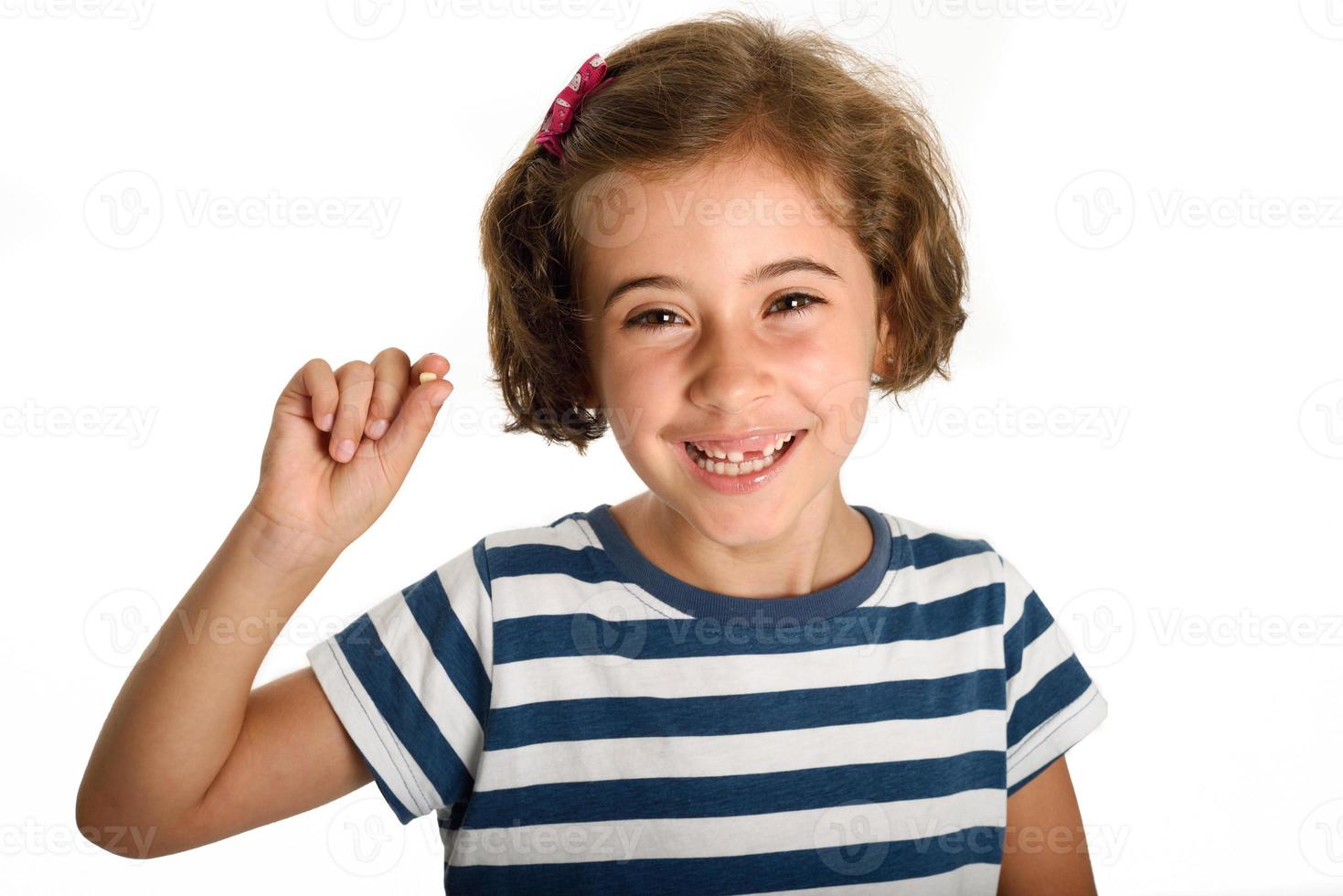 menina feliz mostrando seu primeiro dente caído. foto