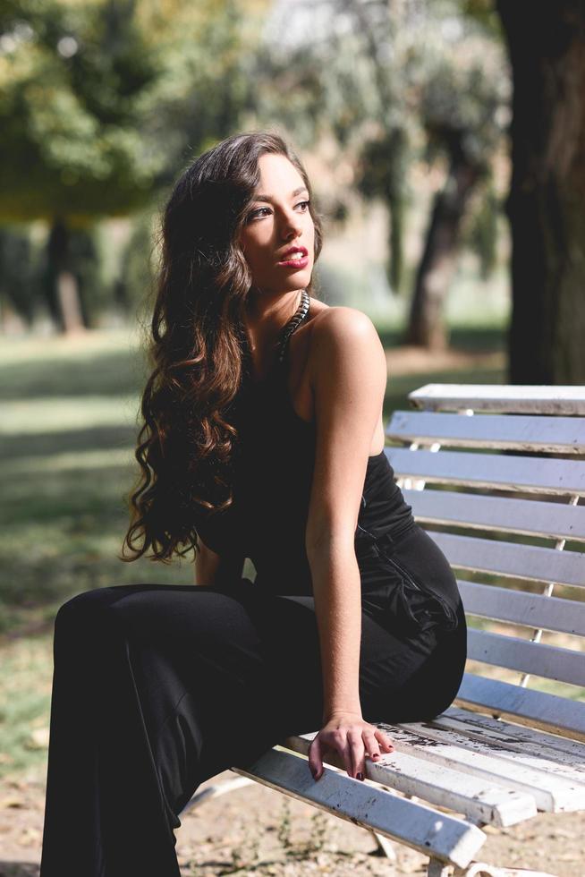 menina bonita vestindo roupas pretas em um parque foto