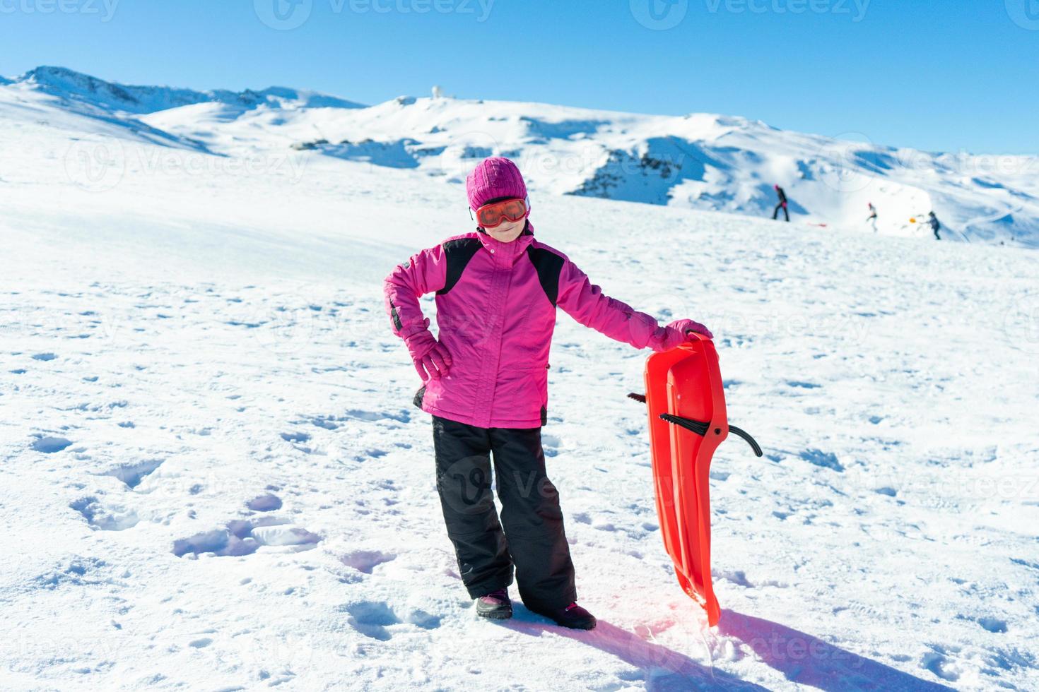 menina andando de trenó na estância de esqui de sierra nevada. foto