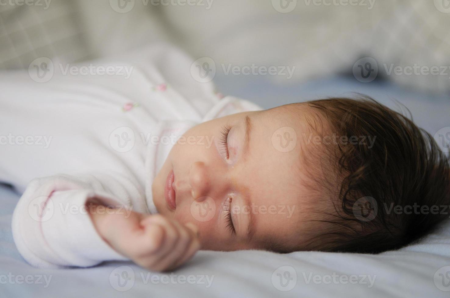 bebê recém-nascido dormindo em lençóis azuis foto