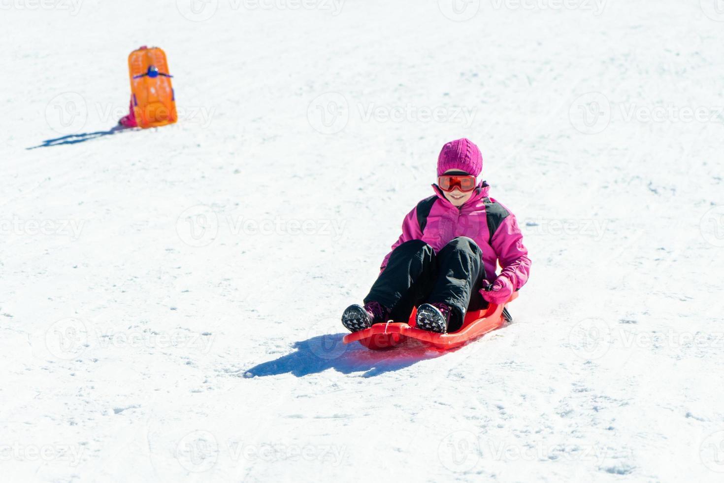 menina andando de trenó na estância de esqui de sierra nevada. foto