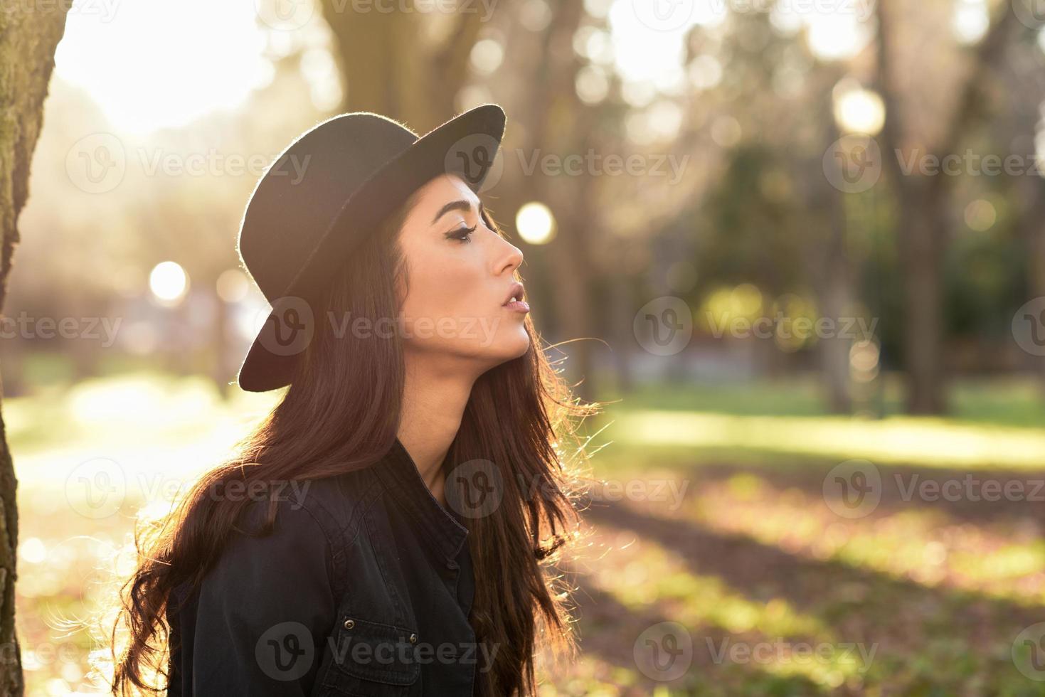 mulher pensativa sentada sozinha ao ar livre com chapéu foto