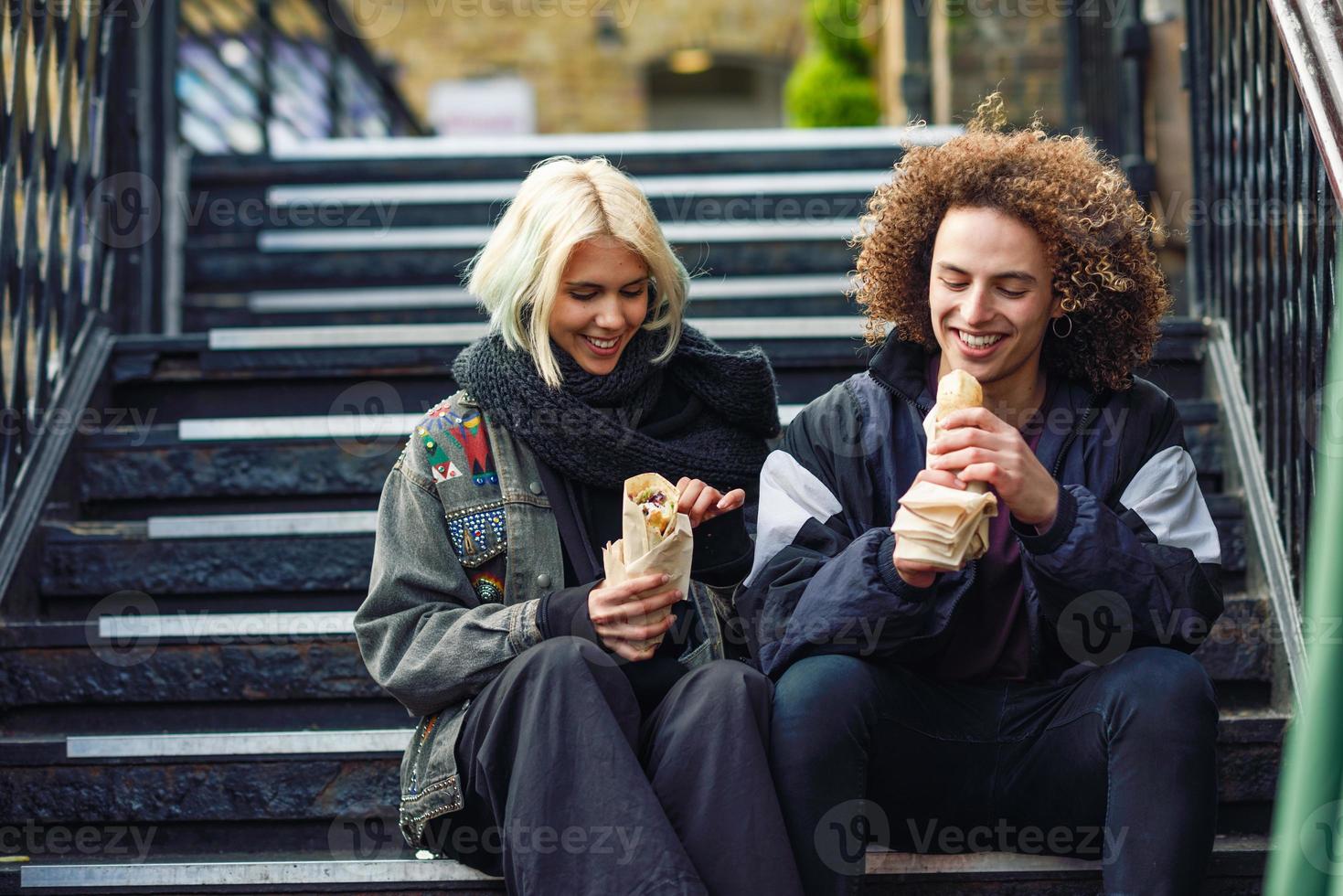 casal feliz comendo doner kebab, shawarma, em camden town foto