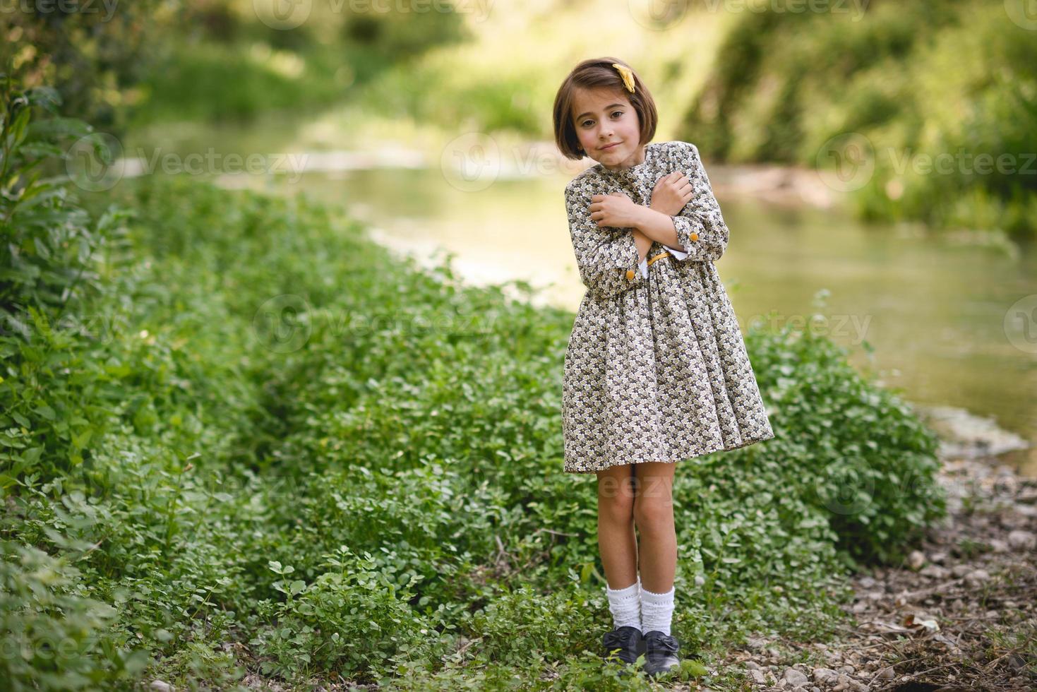 menina no riacho da natureza com um lindo vestido foto