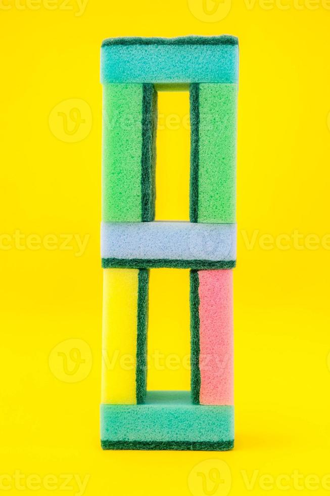 esponjas multicoloridas para limpar pirâmide dobrada em um fundo amarelo foto