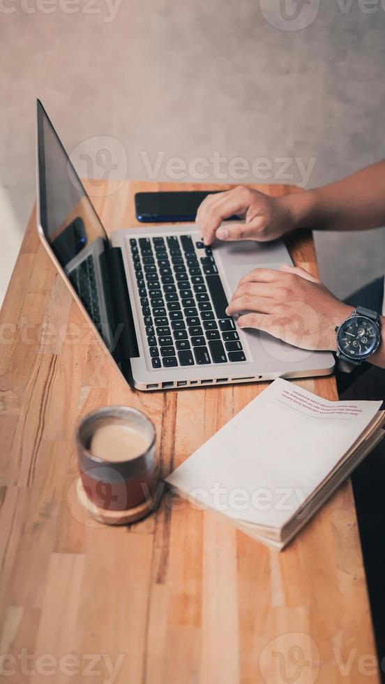 fazendo lição de casa com o laptop enquanto saboreia o café foto