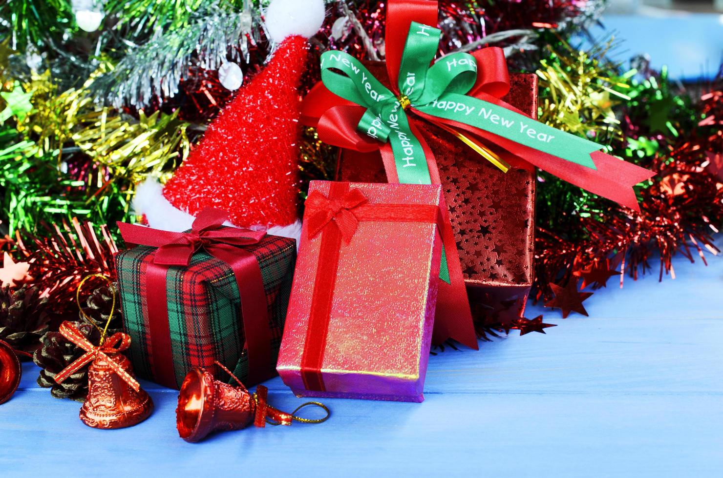 decorações de natal e feliz ano novo fundo com caixa de presente vermelha e chapéu de Papai Noel e decorações foto
