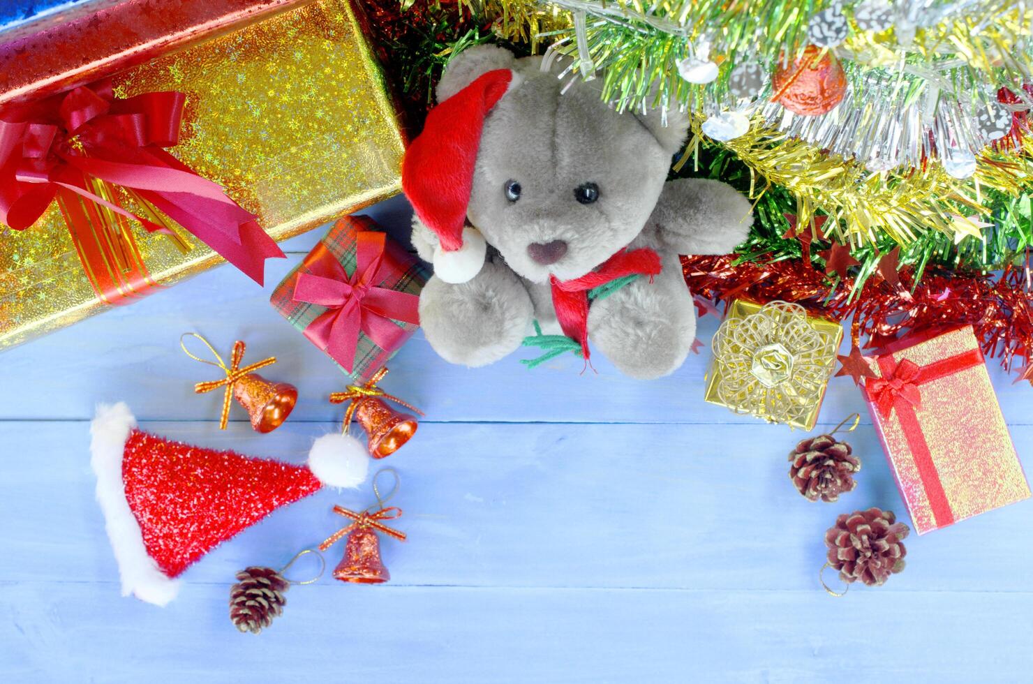 decorações de natal com boneca teedy e chapéu de papai noel e fundos de caixa de presente acima foto