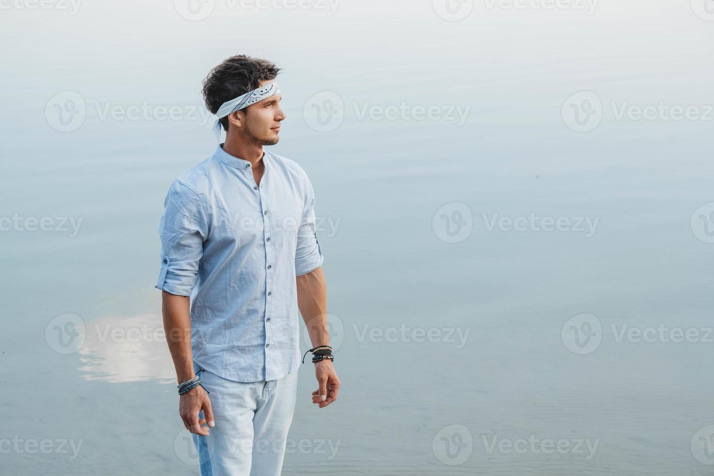 homem vestido com roupas leves olha para a água foto