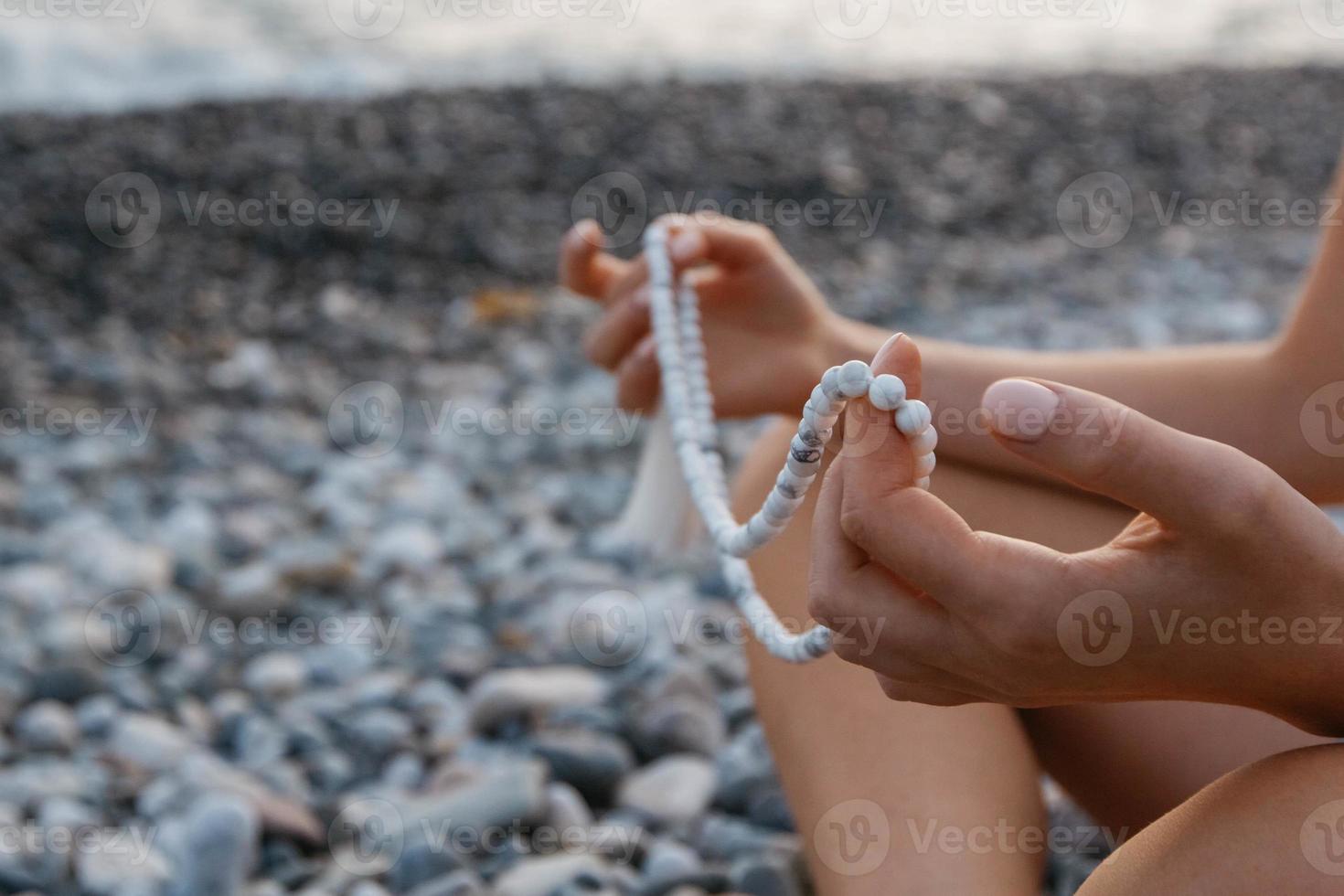 rosário para meditação nas mãos de uma menina foto