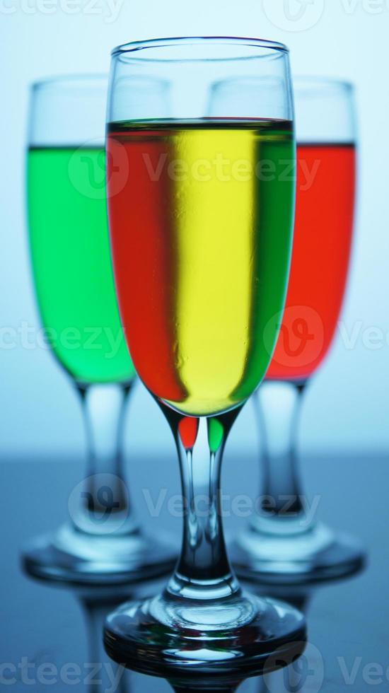 foto de close de bebida em um copo em um bokeh desfocado fundo de copos de bebida coloridos