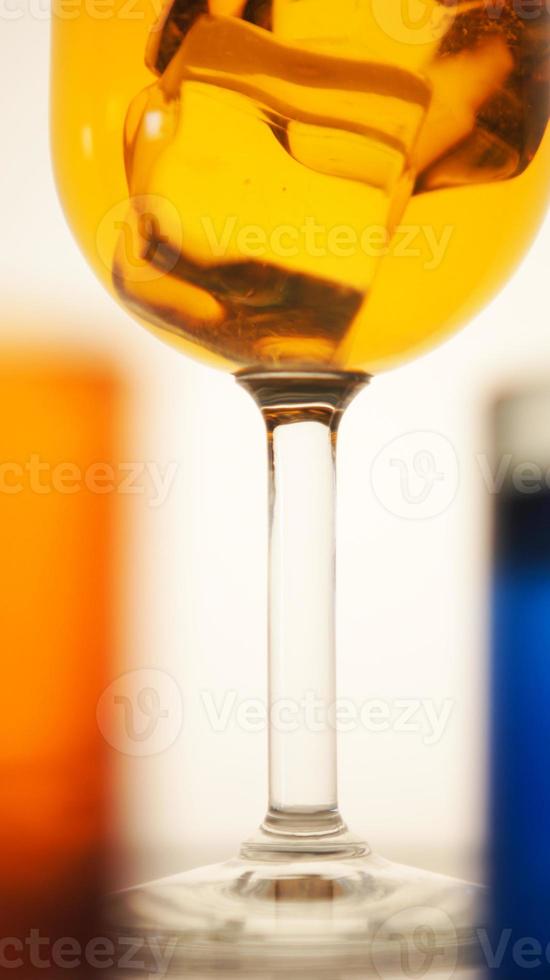 foto do close up de bebida em um copo com cubos de gelo em um bokeh desfocar o fundo de copos de bebida coloridos