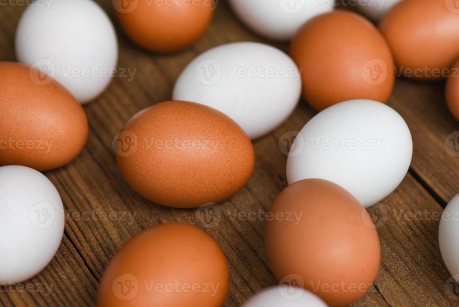 ovos de galinha frescos e ovos de pato em fundo de madeira, natureza de ovo branco e marrom da fazenda foto