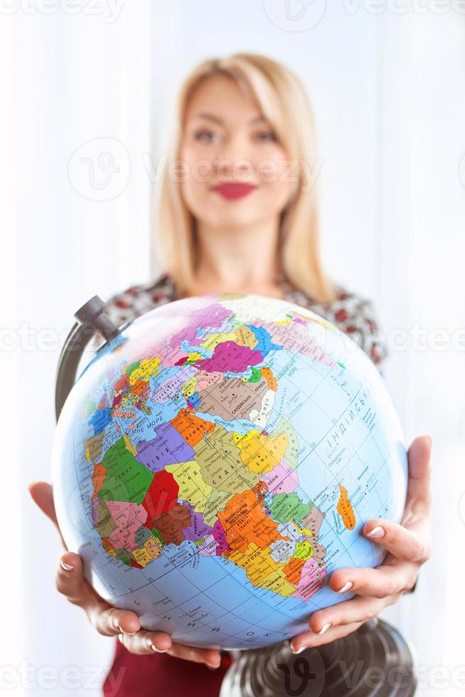 Agente de viagens linda alegre sorridente mulher segurando o globo nas mãos foto