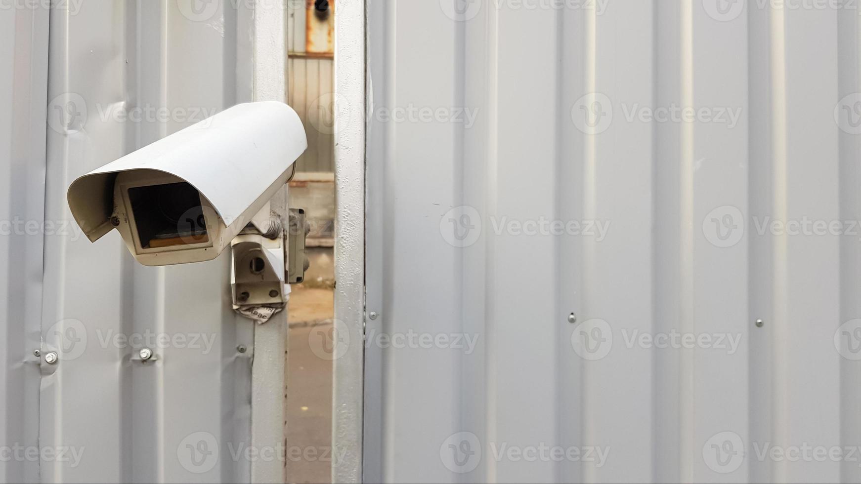 câmera de vigilância em cima de uma cerca de metal ondulado cinza foto