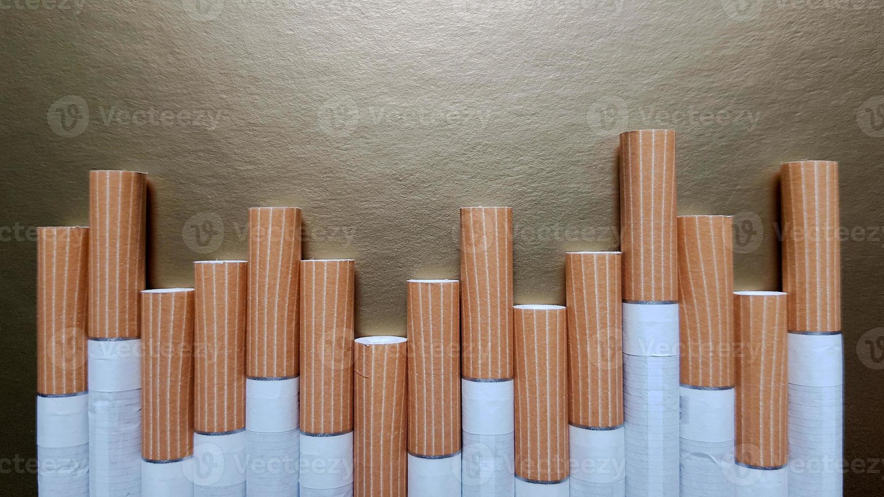imagem de vários cigarros comerciais. pilha de cigarros em um fundo dourado ou conceito de campanha antifumo, tabaco foto