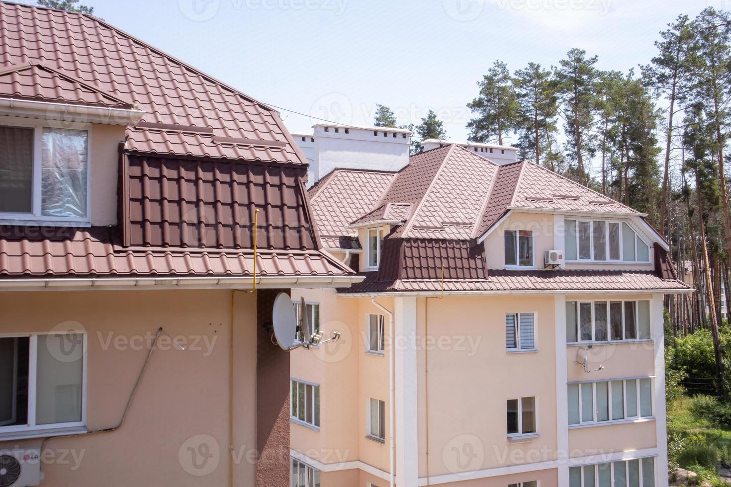 telhado em propriedade residencial com novas telhas de metal ondulado marrom. telhado de metal moderno. coberturas metálicas. foto