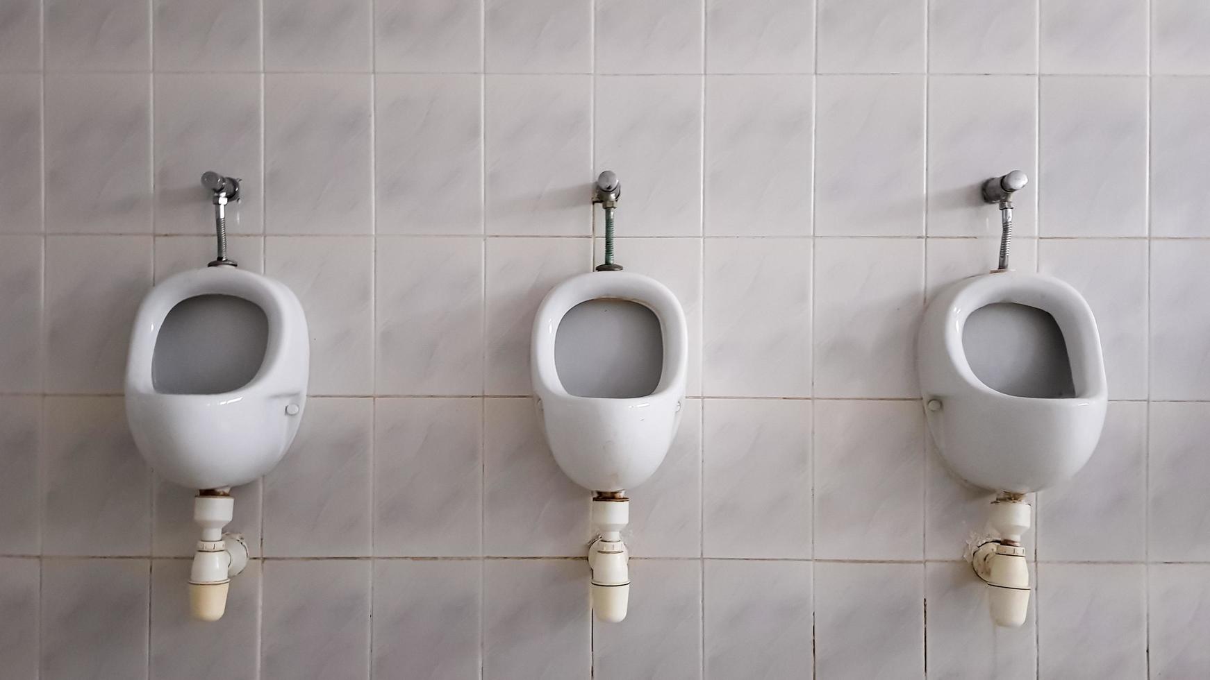 banheiros públicos com muitos urinóis de cerâmica. grande banheiro público, tigelas fixadas na parede no banheiro. os mictórios preparam tigelas para os homens. foto