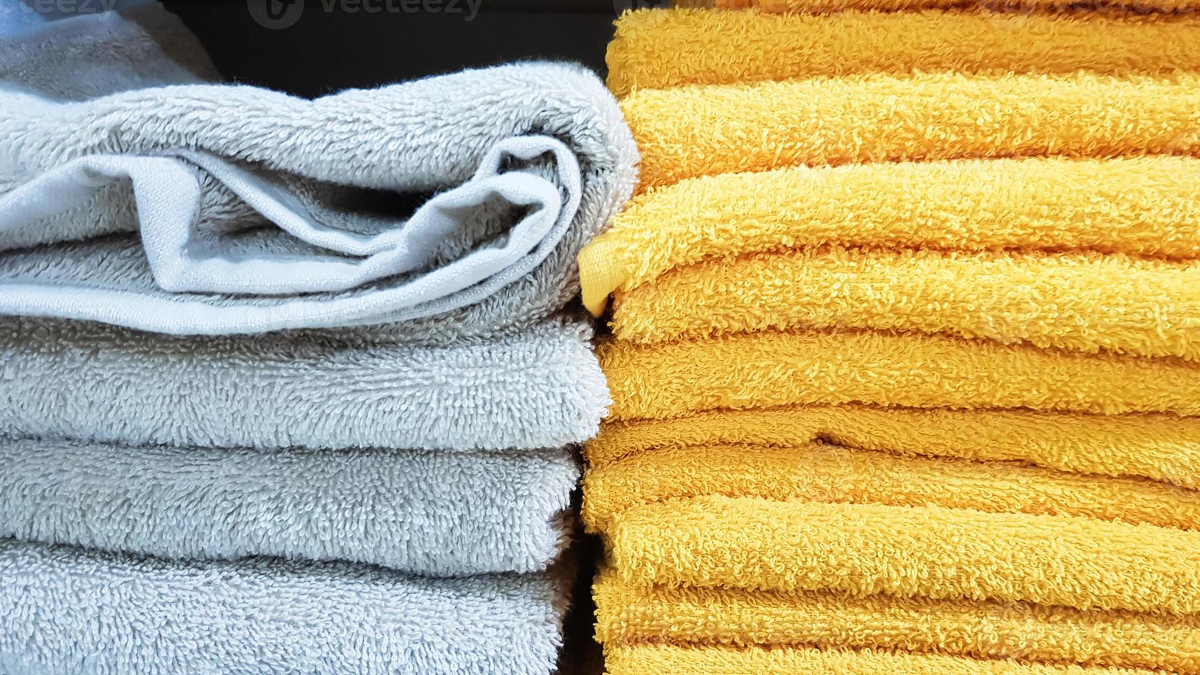 pilhas de toalhas de banho macias de várias cores em uma vitrine. toalhas de algodão turco empilhadas nas prateleiras de um supermercado. foto