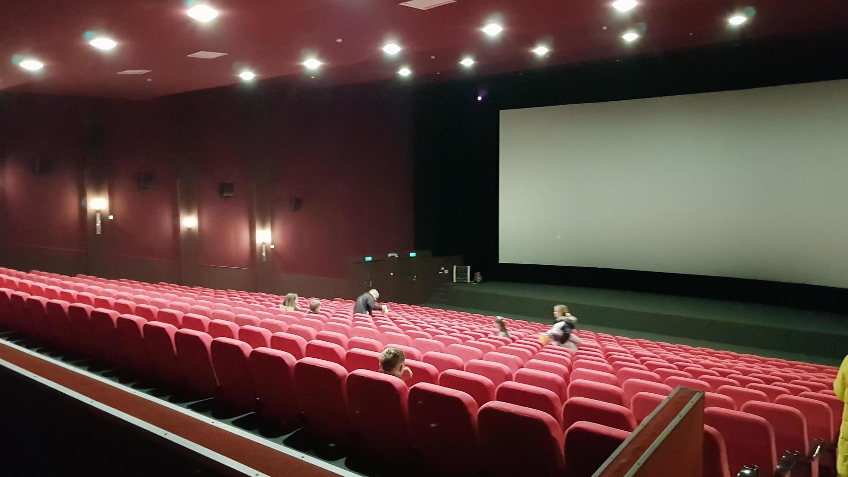 Ucrânia, Kiev - 2 de junho de 2020. plano de fundo do assento vermelho em um cinema sem pessoas. assentos teatrais e uma tela branca foto