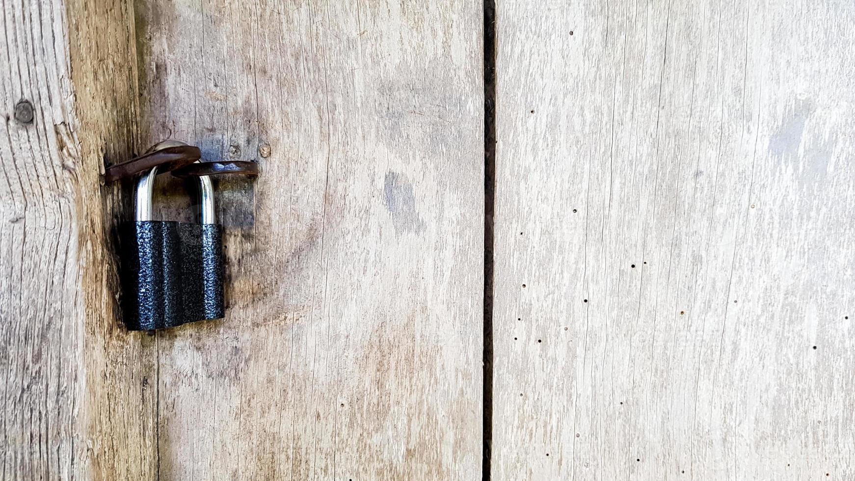 velho cadeado de metal vintage em uma porta de madeira fechada de uma antiga casa de fazenda. o verdadeiro estilo da aldeia. fechar-se. concentre-se no castelo. fundo de madeira, textura. copie o espaço foto