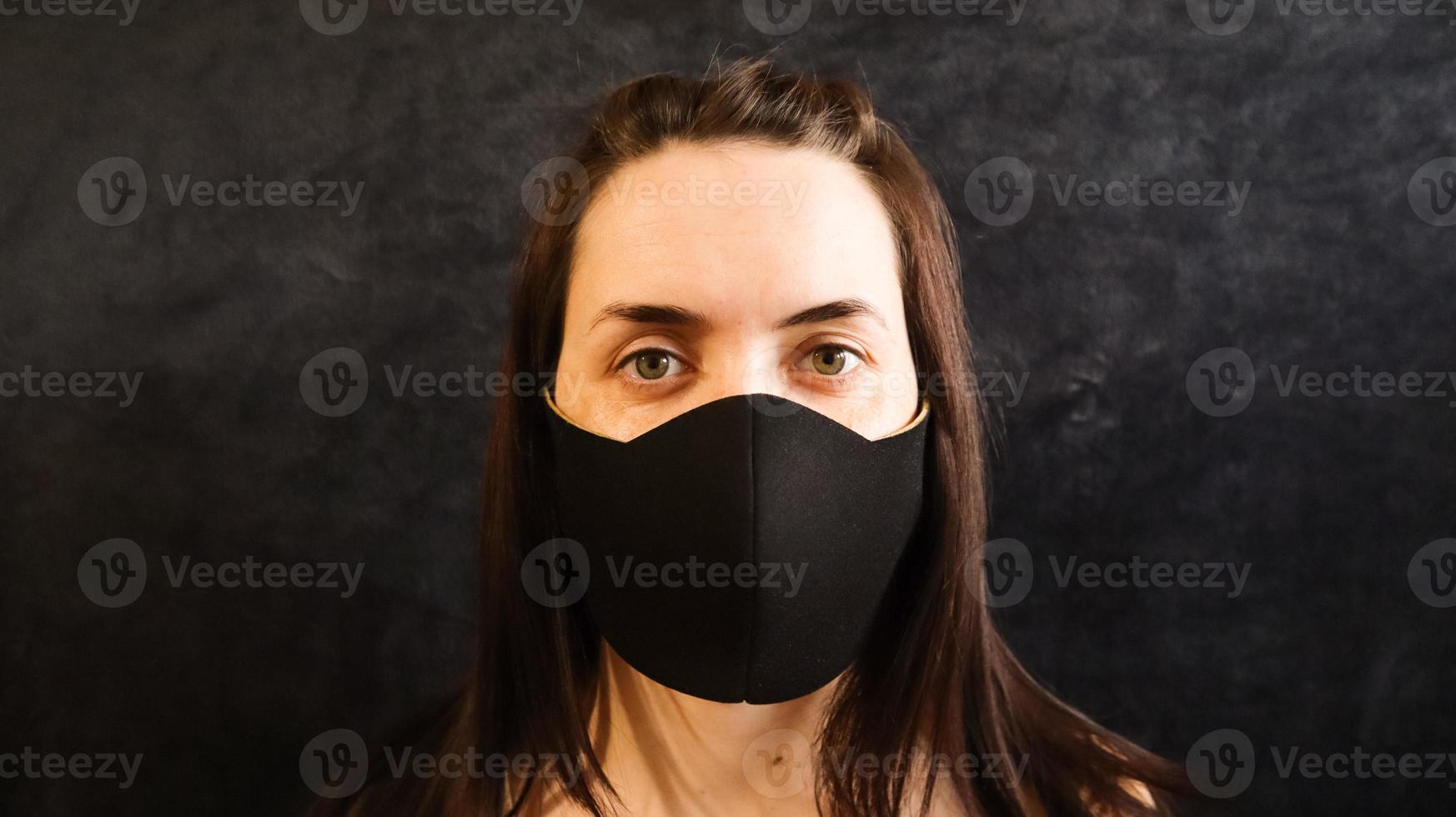 retrato de uma mulher, jovem usando uma máscara médica facial higiênica para evitar infecção, doença ou gripe e nkov 2019. fundo cinza. proteção contra doenças, coronavírus. foto