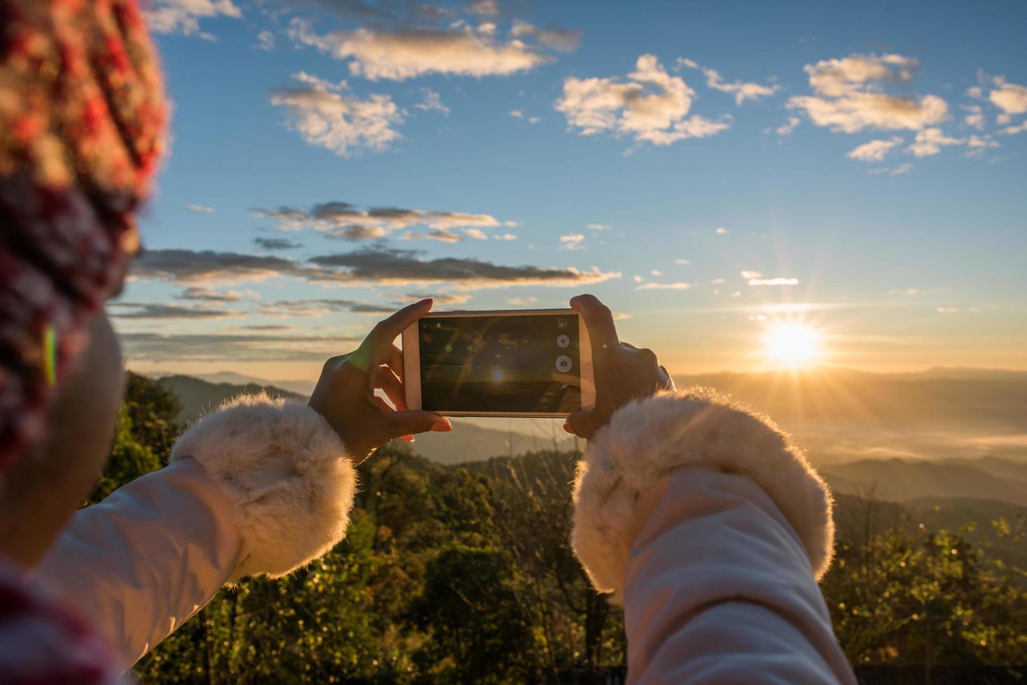 mão segurando um smartphone tira uma foto linda montanha