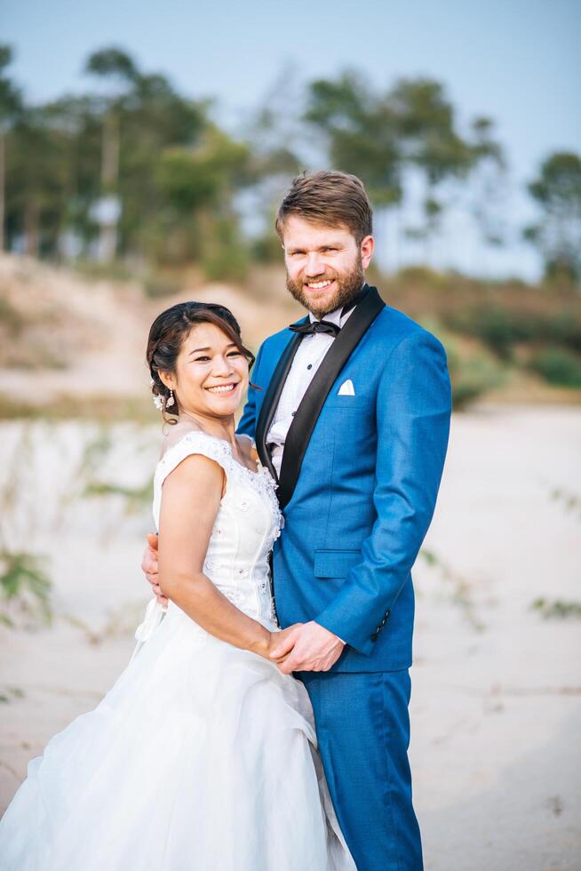 Noiva asiática e noivo caucasiano têm tempo de romance e felizes juntos foto