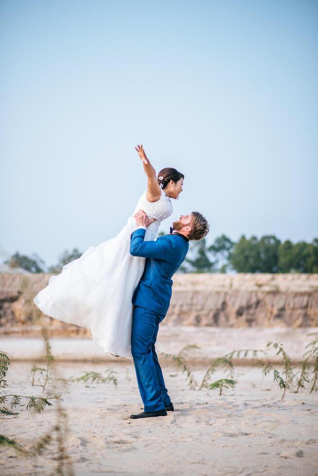 Noiva asiática e noivo caucasiano têm tempo de romance e felizes juntos foto