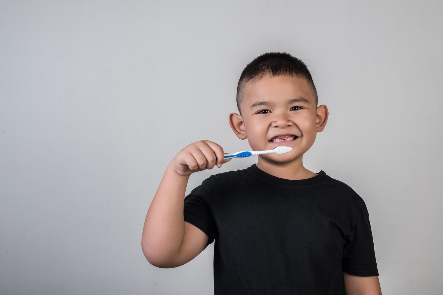 garotinho escovando os dentes em foto de estúdio