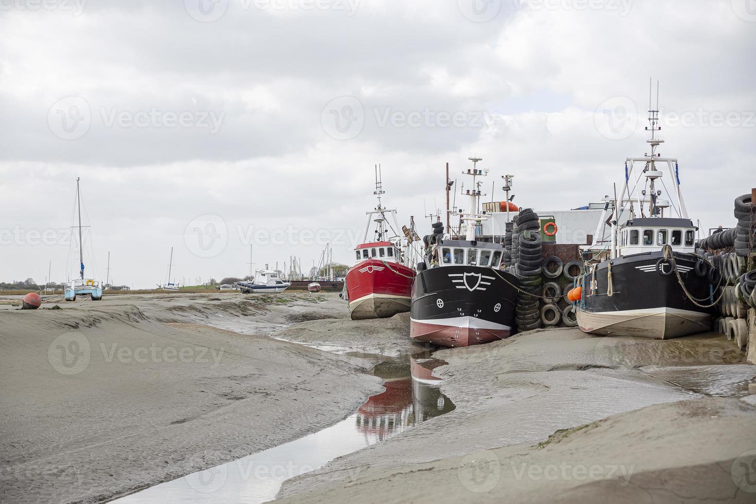 barcos de pescadores presos na praia no período de maré baixa. foto