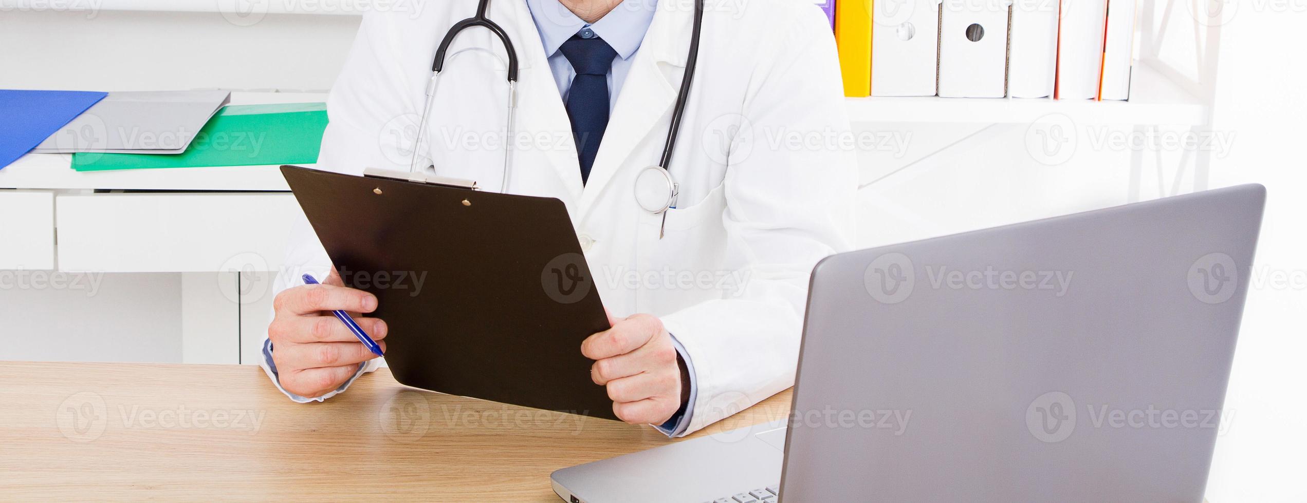 retrato do médico sênior no consultório médico. homem de uniforme branco foto