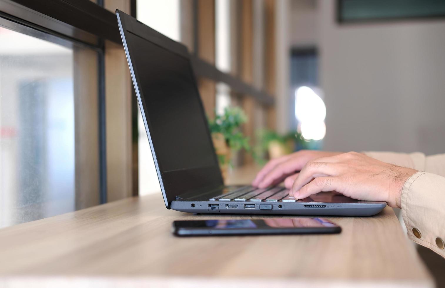 homem usando laptop online, sentado à mesa do escritório, olhando para a tela do computador, homem focado usando internet banking, enviando e-mail e procurando informações foto