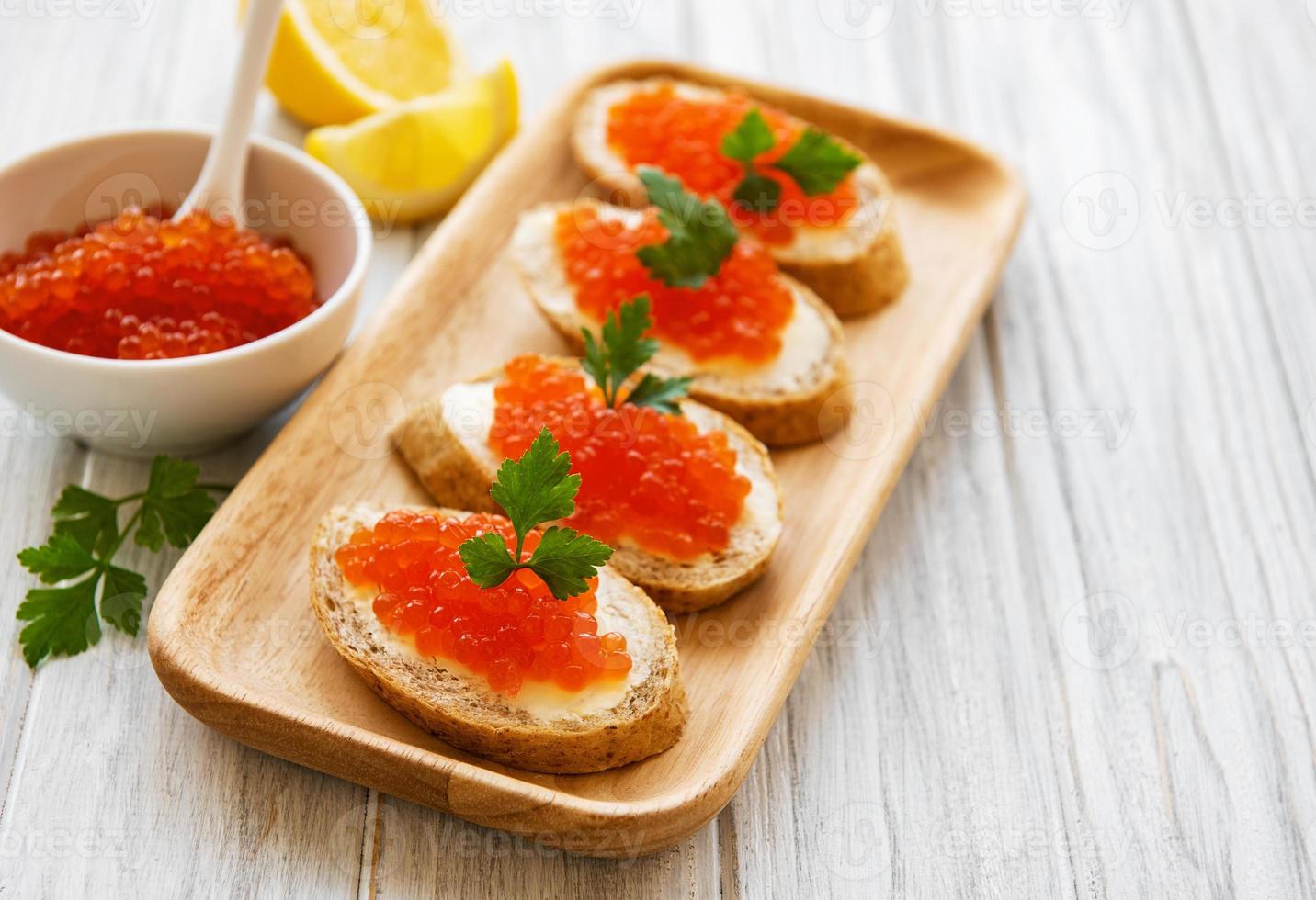 caviar vermelho na tigela e sanduíches foto