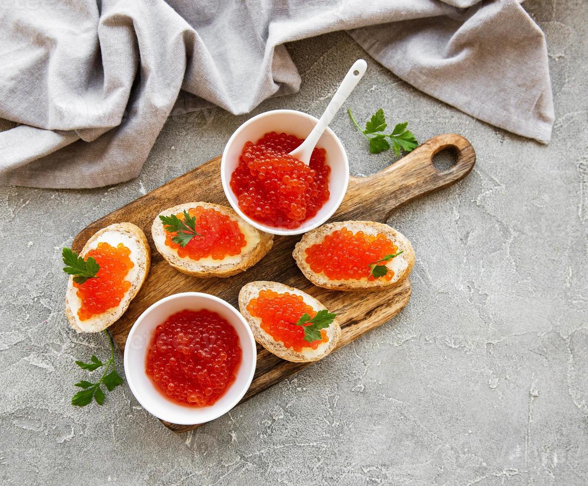 caviar vermelho na tigela e sanduíches foto