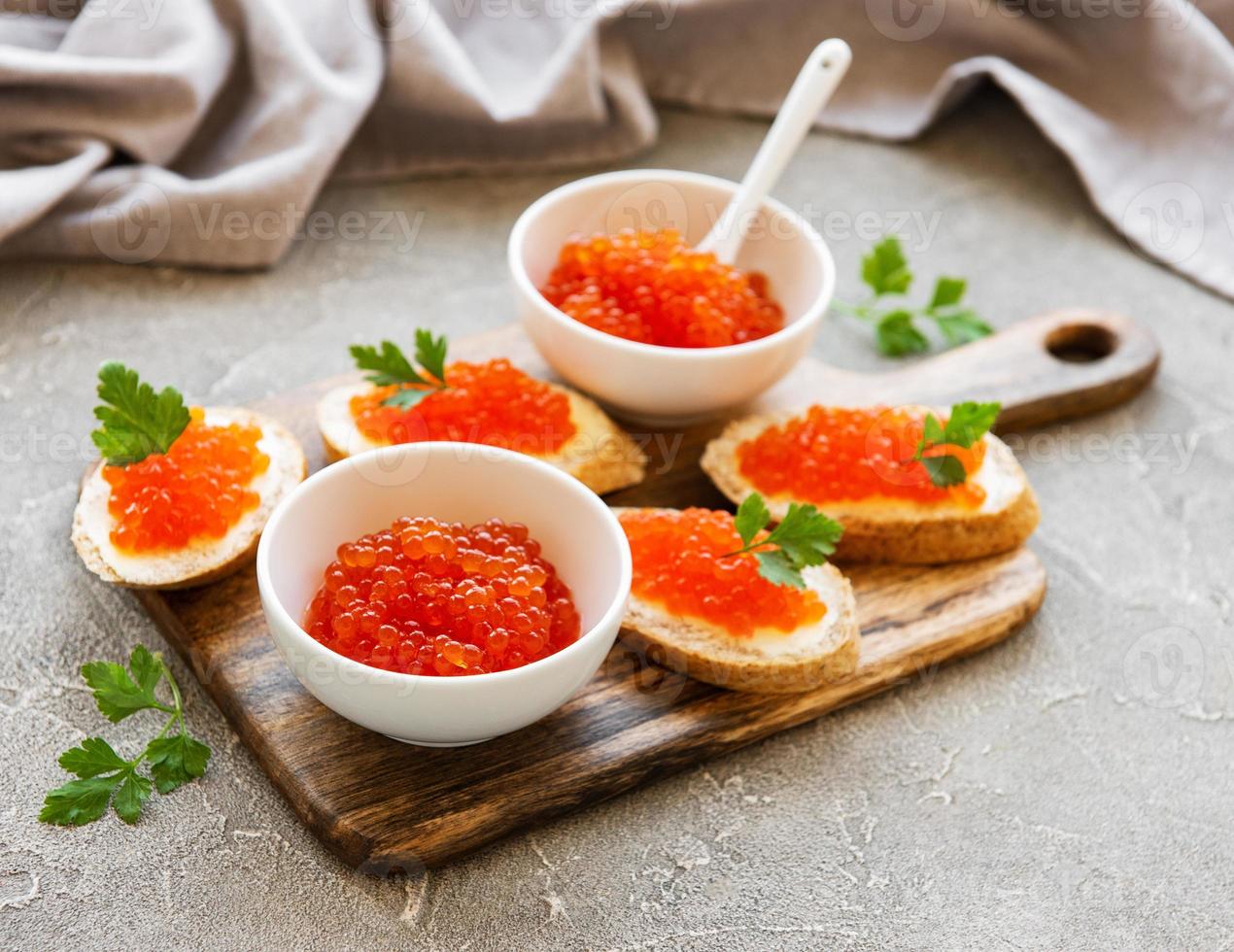 caviar vermelho na tigela e sanduíches foto