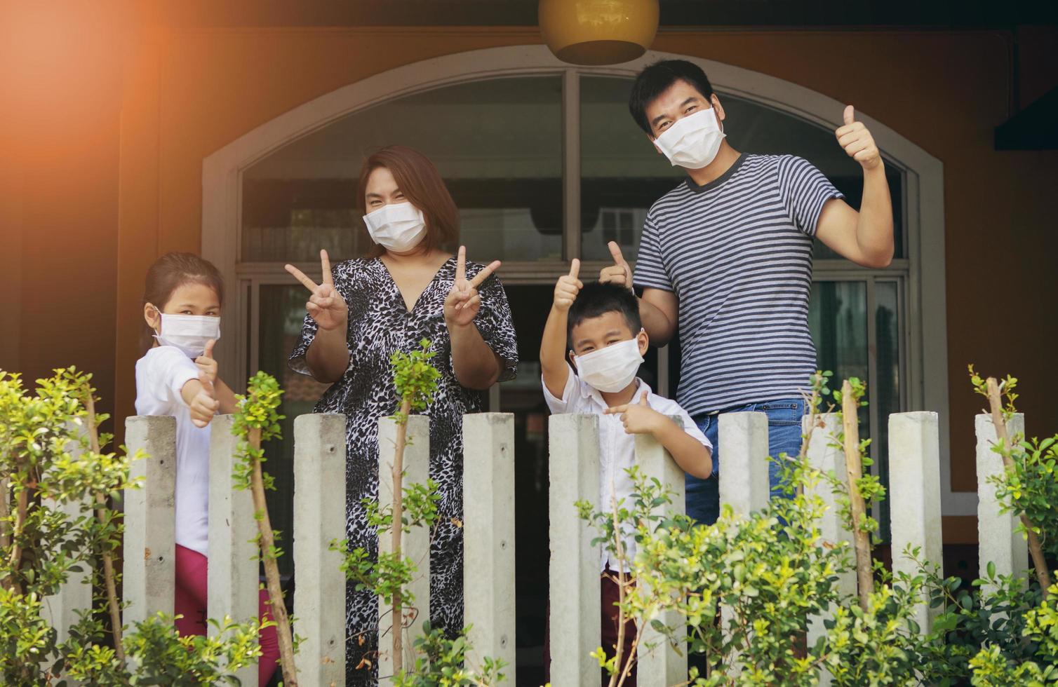Família asiática usando máscara de proteção em pé de quarentena foto