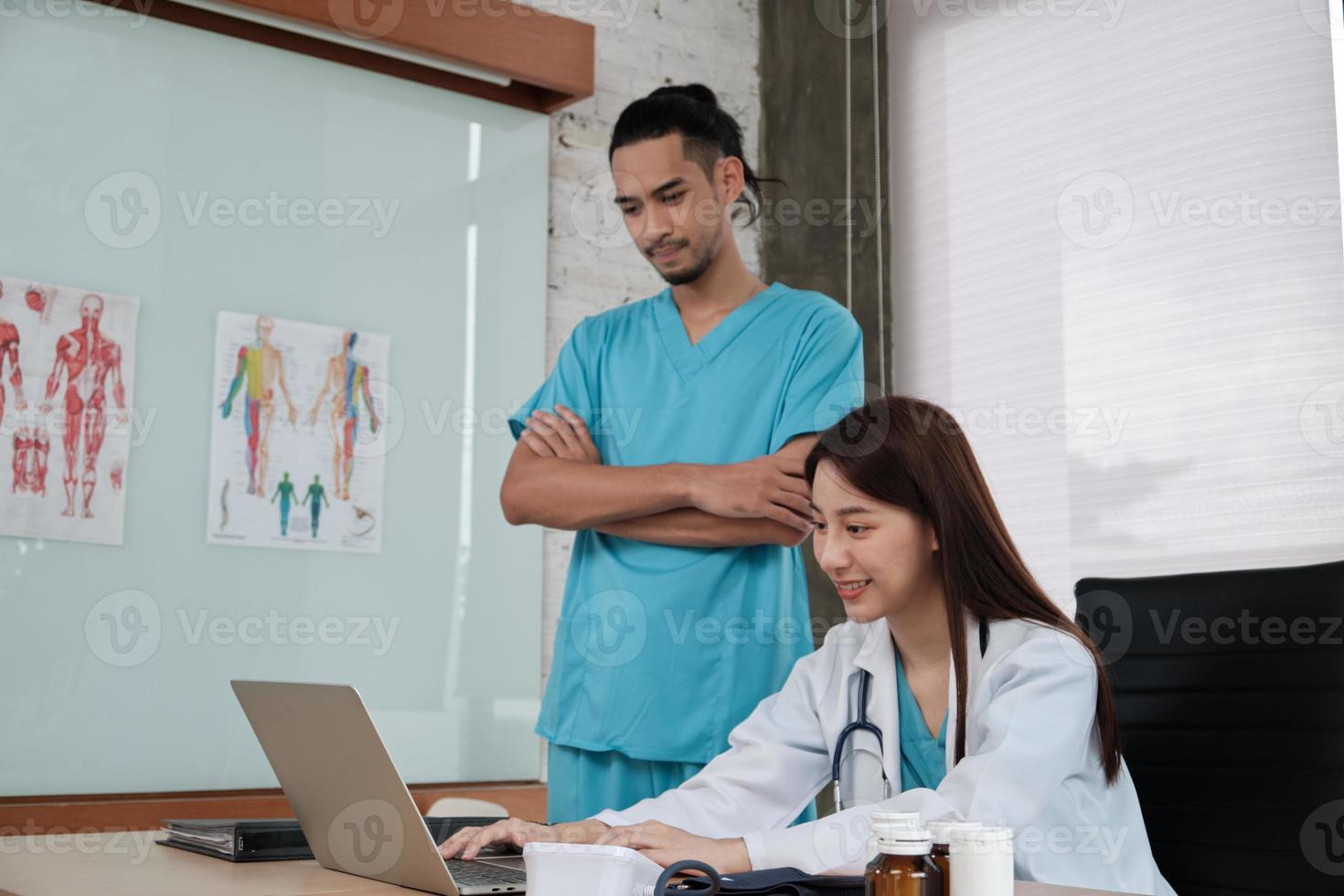 parceiros da equipe de saúde. dois médicos uniformizados de etnia asiática jovens são colegas de trabalho discutindo medicamentos no consultório da clínica do hospital. pessoas especializadas são especialistas e profissionais. foto