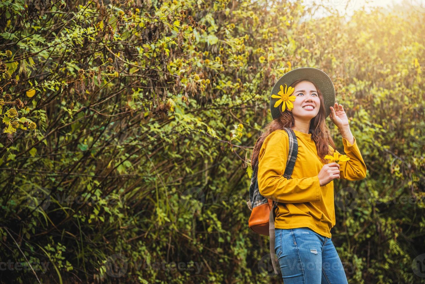 natureza turística asiática, relaxando apreciando a beleza fresca da flor. ela sorriu e escolheu o amarelo da flor bua tong. foto