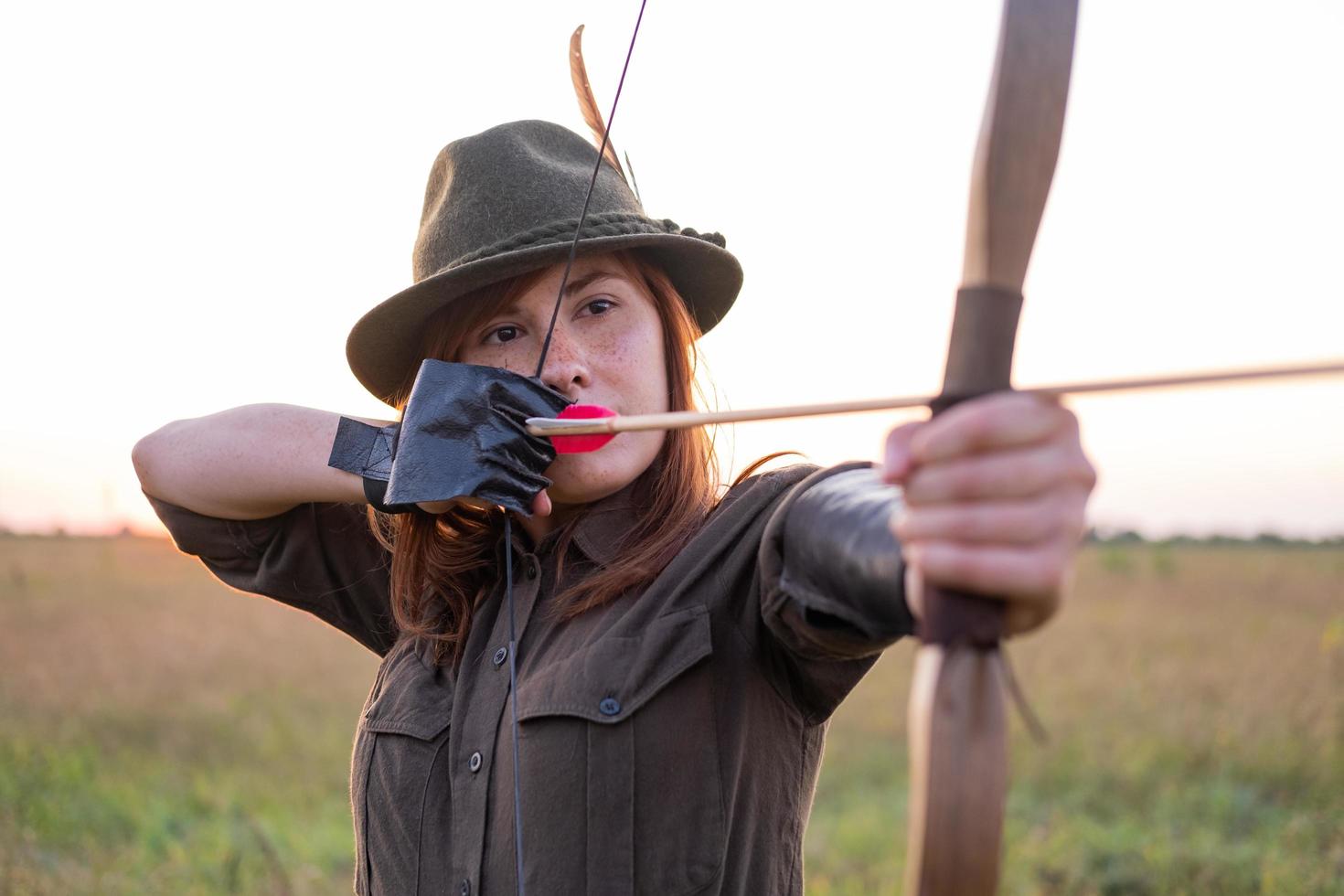 mulher com arco ao ar livre no campo foto