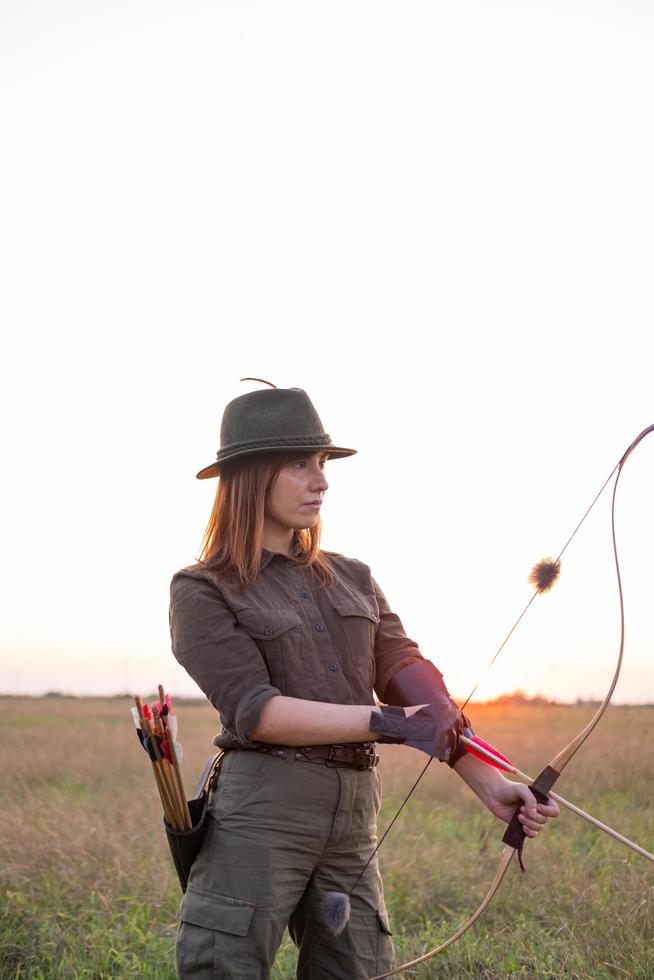 mulher com arco ao ar livre no campo foto