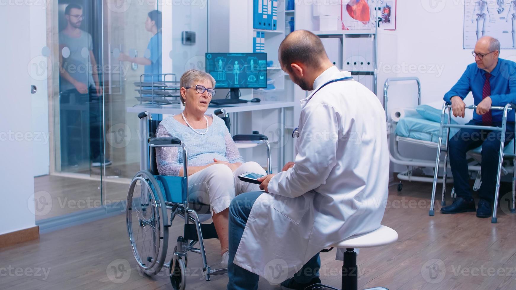 médico com tablet digital dando conselhos médicos em clínica de recuperação foto