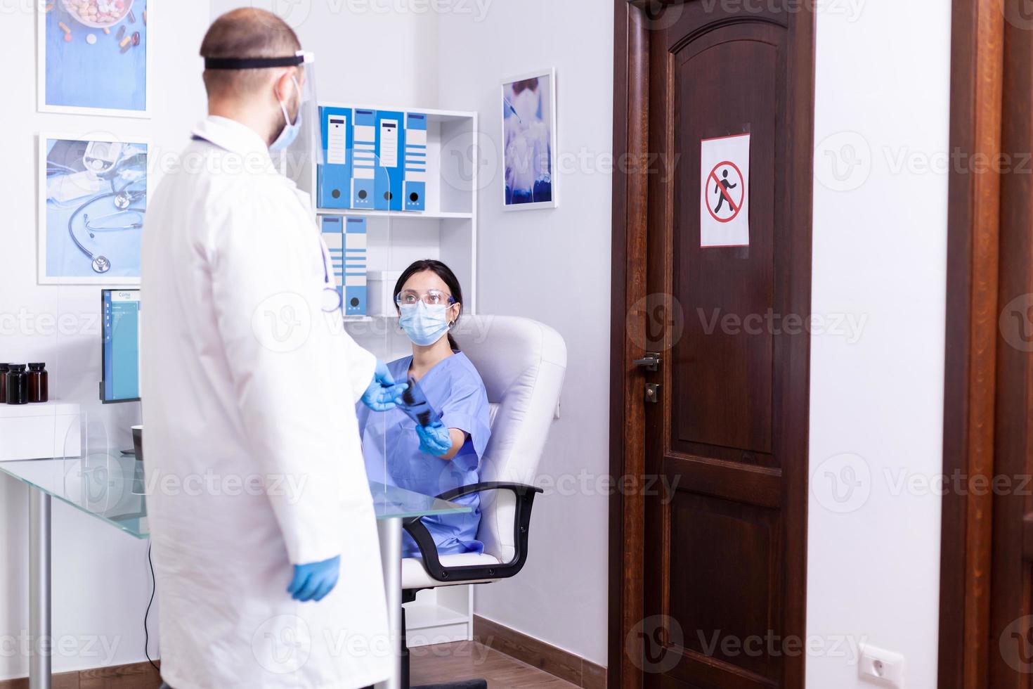 médico fazendo radiografia de paciente para enfermeira foto