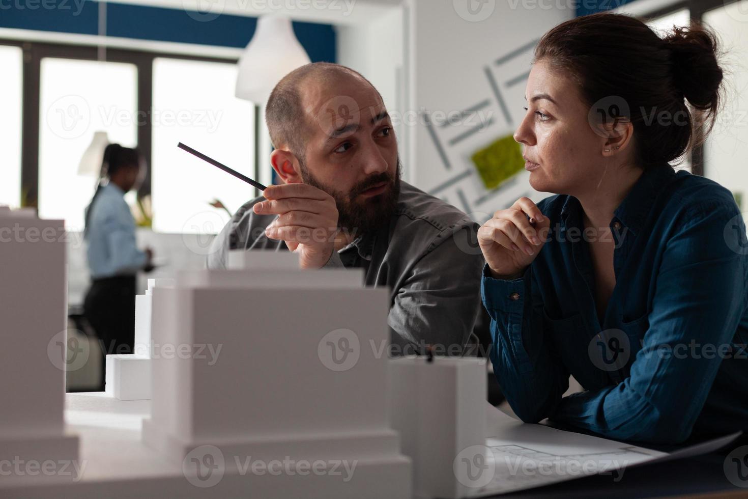 grupo de arquitetos de engenharia sentado no escritório discutindo foto