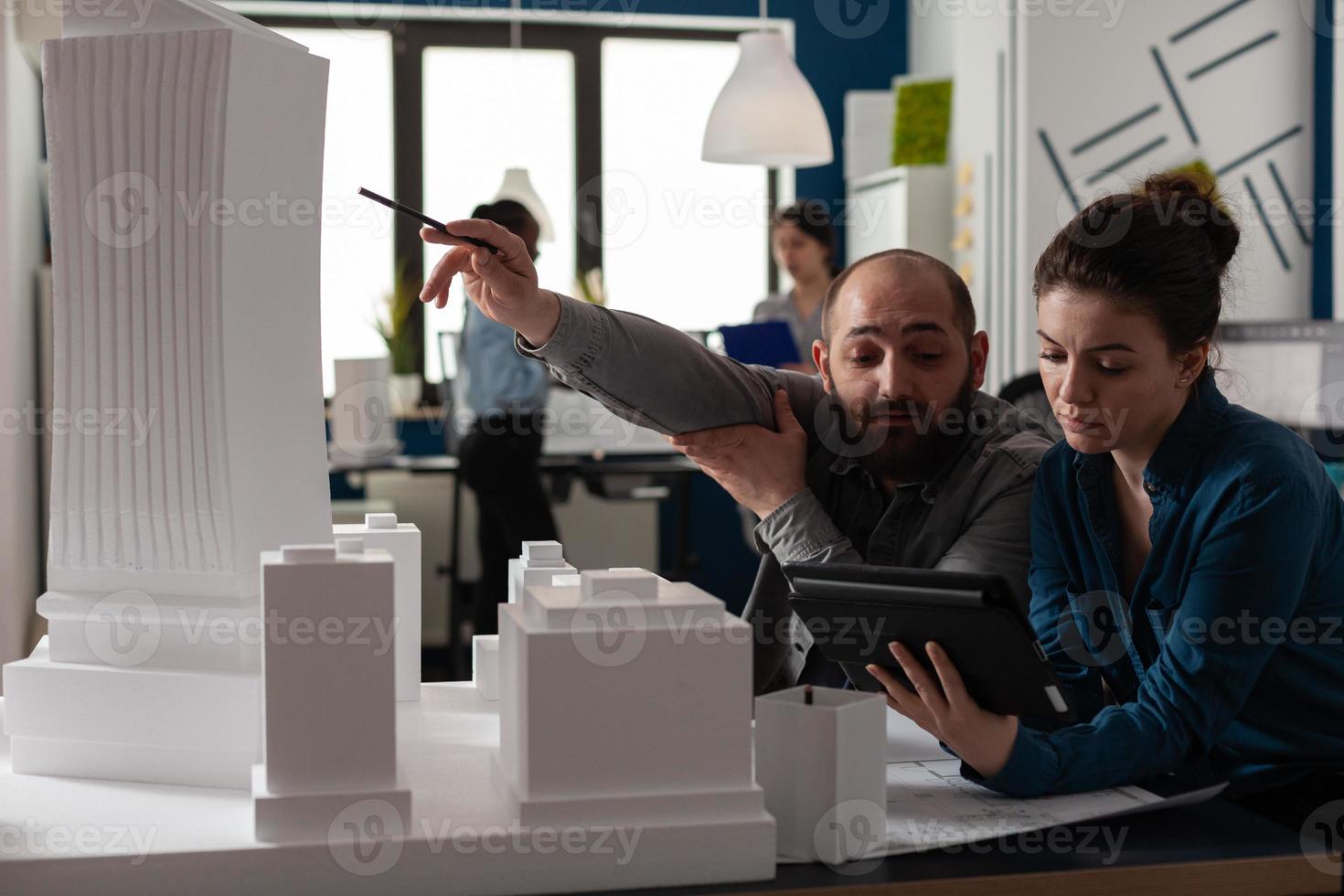 equipe de arquitetos de construção trabalhando em tablet no escritório foto