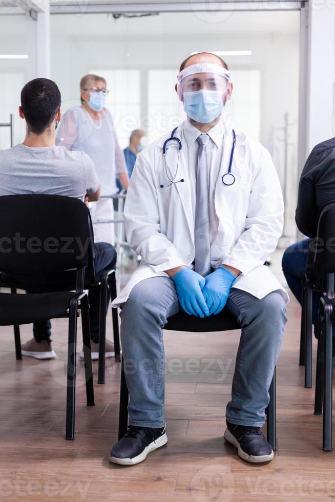 médico exausto na sala de espera do hospital foto