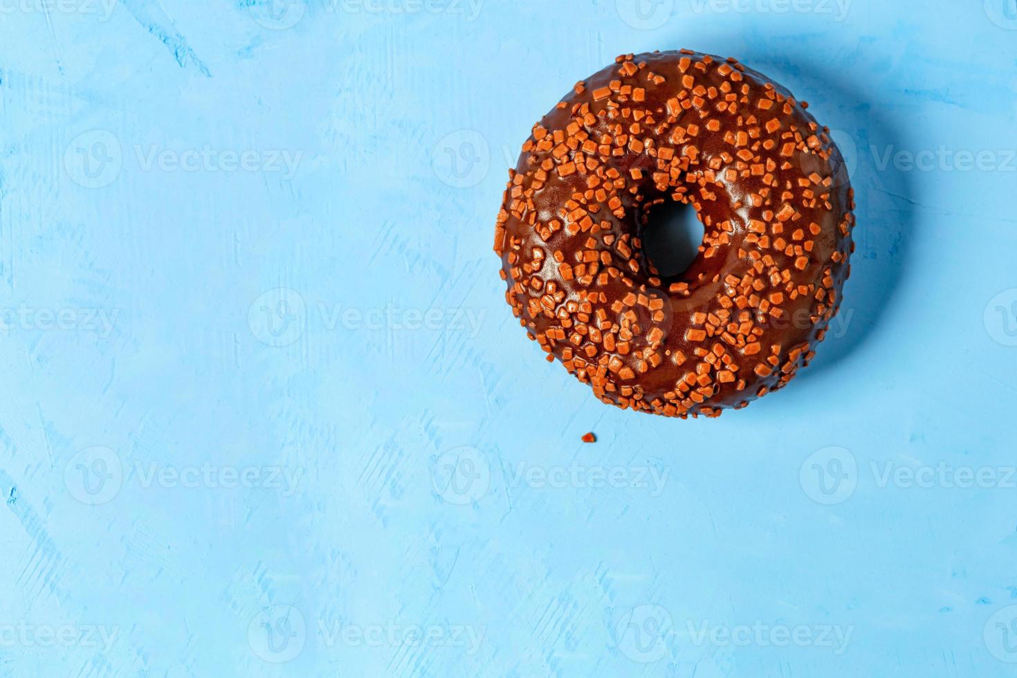 delicioso donut de chocolate em uma superfície de concreto azul. foto